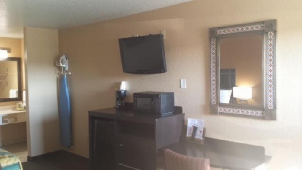 Bathroom sink built in shelving and iron board hook at Sona Inn Dilley Texas